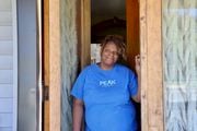 Lasasha Lemons-Taylor smiles at the front door of her house on S. Geddes St in Syracuse. She says she is trying to stay optimistic about the work that has to be done on the house after a fire started by squatters in the house next to hers caused damage (Melissa Newcomb|mnewcomb@syracuse.com).