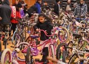 Parents and children leave Jan Maloff's 2018 Family Bike Giveaway with donated bikes. The 2023 bike giveaway is Saturday, Dec. 23 at PSLA at Fowler High School (Michael Greenlar).