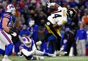 Pittsburgh Steelers wide receiver George Pickens (14) is tripped up by Buffalo Bills safety Micah Hyde (23) third quarter of an NFL wild-card playoff football game, Monday, Jan. 15, 2024, in Buffalo, N.Y. (AP Photo/Adrian Kraus)