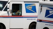 The United States Postal Service logo is shown on the sides of delivery vans headed out from the post office Monday, Aug. 17, 2020, in Greenwood Village, Colo.