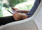 A close-up image of a girl's hands, holding a digital tablet computer. (Getty Images) Columnist Leslie Kouba says screen time is the hobby that keeps us from better things.